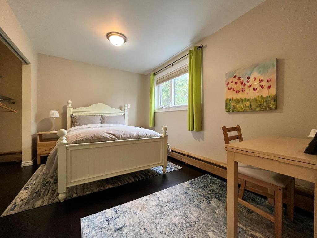 a bedroom with a bed and a desk and a window at Sunshine Guest House Yellowknife in Yellowknife