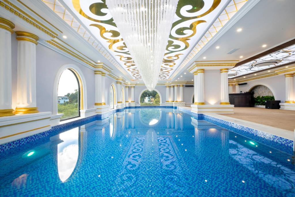 una grande piscina con soffitto e lampadario a braccio di Glenda Tower Moc Chau Hotel a Mộc Châu