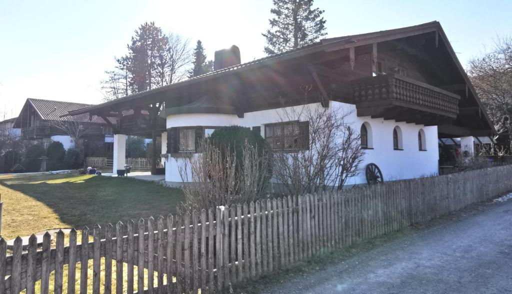 ein weißes Haus mit einem Zaun davor in der Unterkunft Ferienhaus Luise in Samerberg