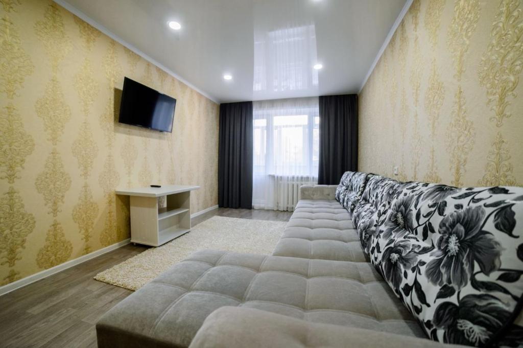 a living room with a couch and a television at Квартира in Temirtaū