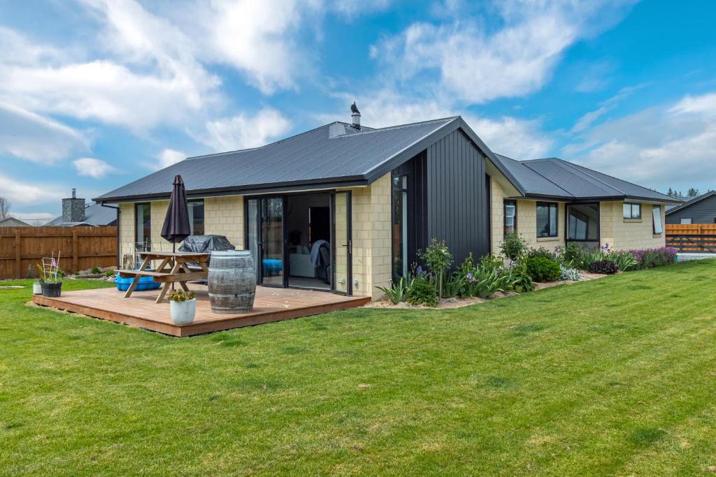 a house with a deck in a yard at Just like home - Methven in Methven