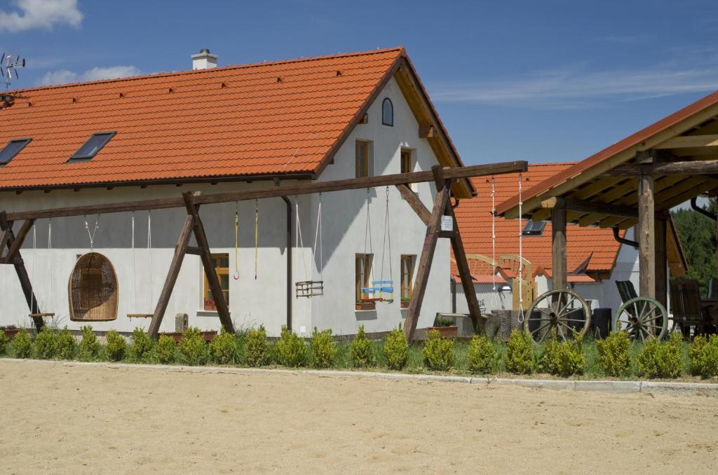 a white building with an orange roof at Apartmány Agroklubu na Radosti in Komorovice