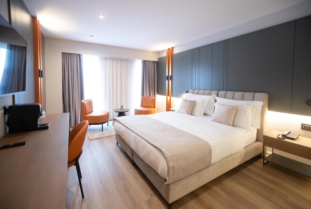 Pokój hotelowy z dużym łóżkiem i biurkiem w obiekcie Hotel Elisa Tirana, Affiliated by Meliá w Tiranie
