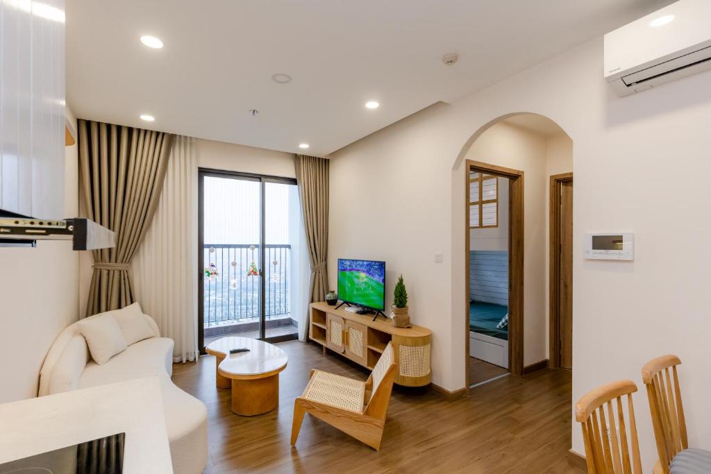 a living room with a couch and a tv at Ecopark - Lullaby Home Ecopark in HÆ°ng YÃªn