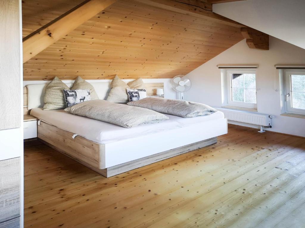 a large bed in a room with a wooden ceiling at Haus Matzenblick in Reith im Alpbachtal