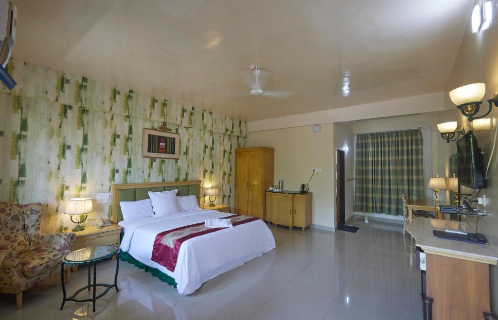 a bedroom with a large bed and a bathroom at Mango Valley Resort Ganpatipule in Ratnagiri