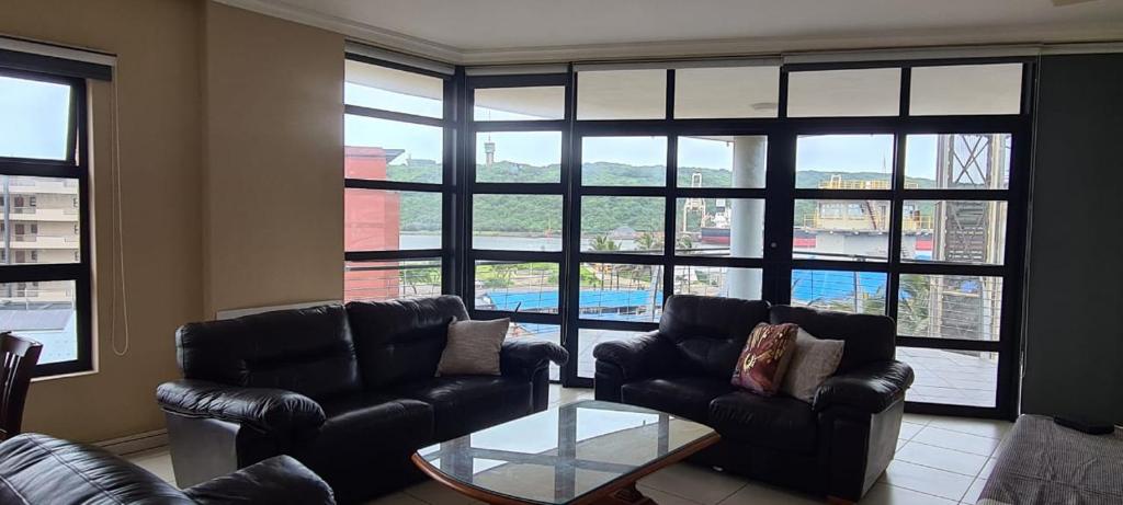 - un salon avec des canapés et une table en verre dans l'établissement 39 Harbour View, à Durban