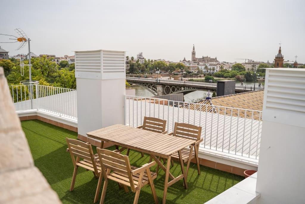 einen Holztisch und Stühle auf dem Balkon in der Unterkunft Optimus Apartments Corazón de Triana in Sevilla