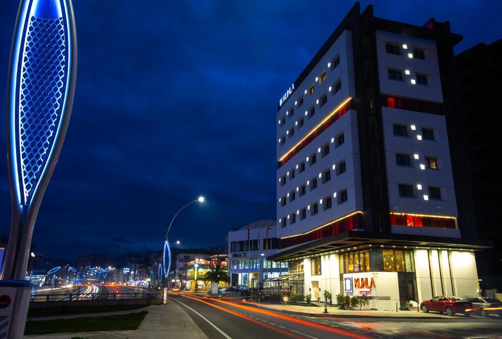 a tall building on a city street at night at Kuhla Hotel in Trabzon