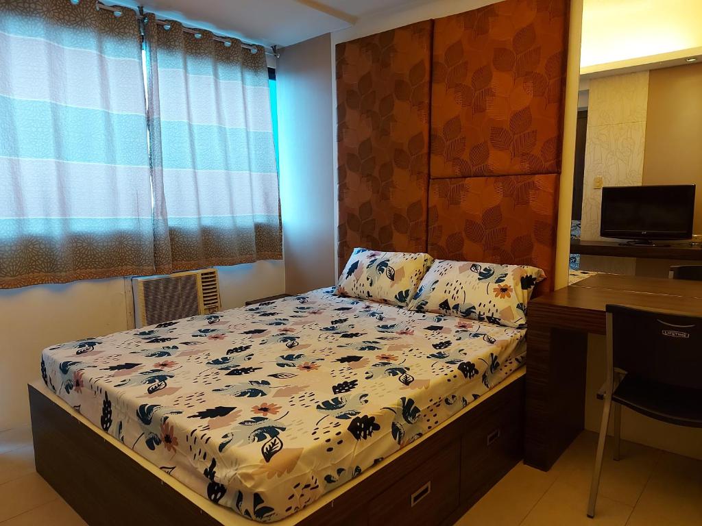 Habitación pequeña con cama y escritorio. en Romantic 1 Bedroom with Pool en Manila