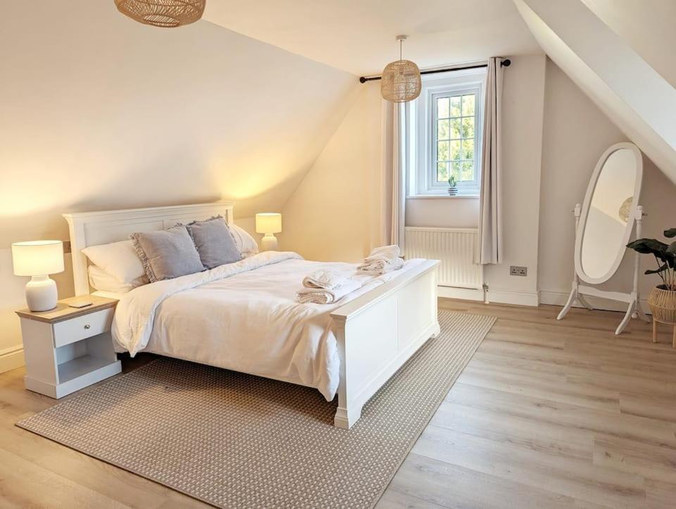 a bedroom with a white bed and a large window at Seaside Cottage, 8min walk to beach. Dog friendly. in Norwich