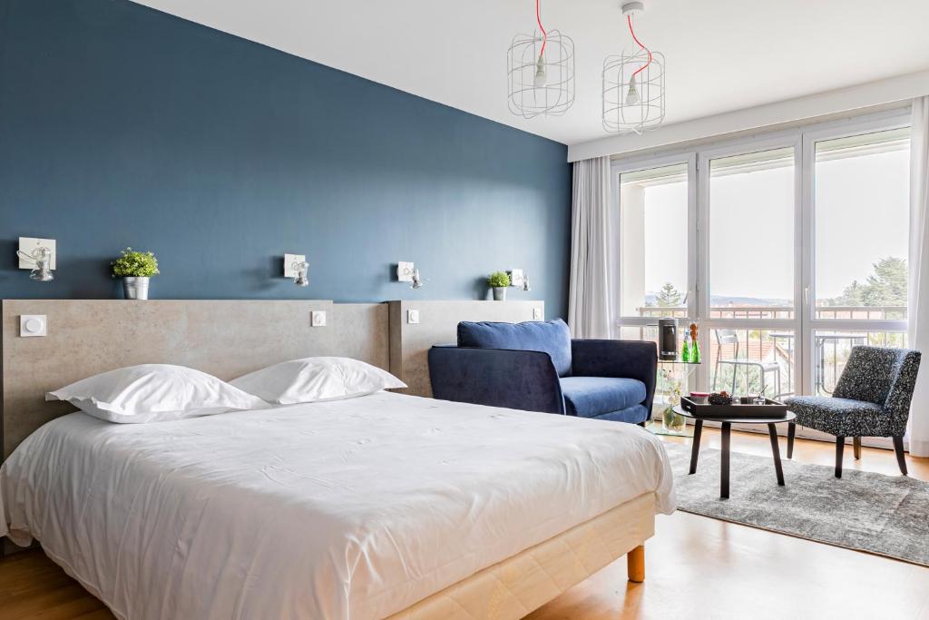 1 dormitorio con cama y pared azul en Hôtel Vulcain, en LʼHorme