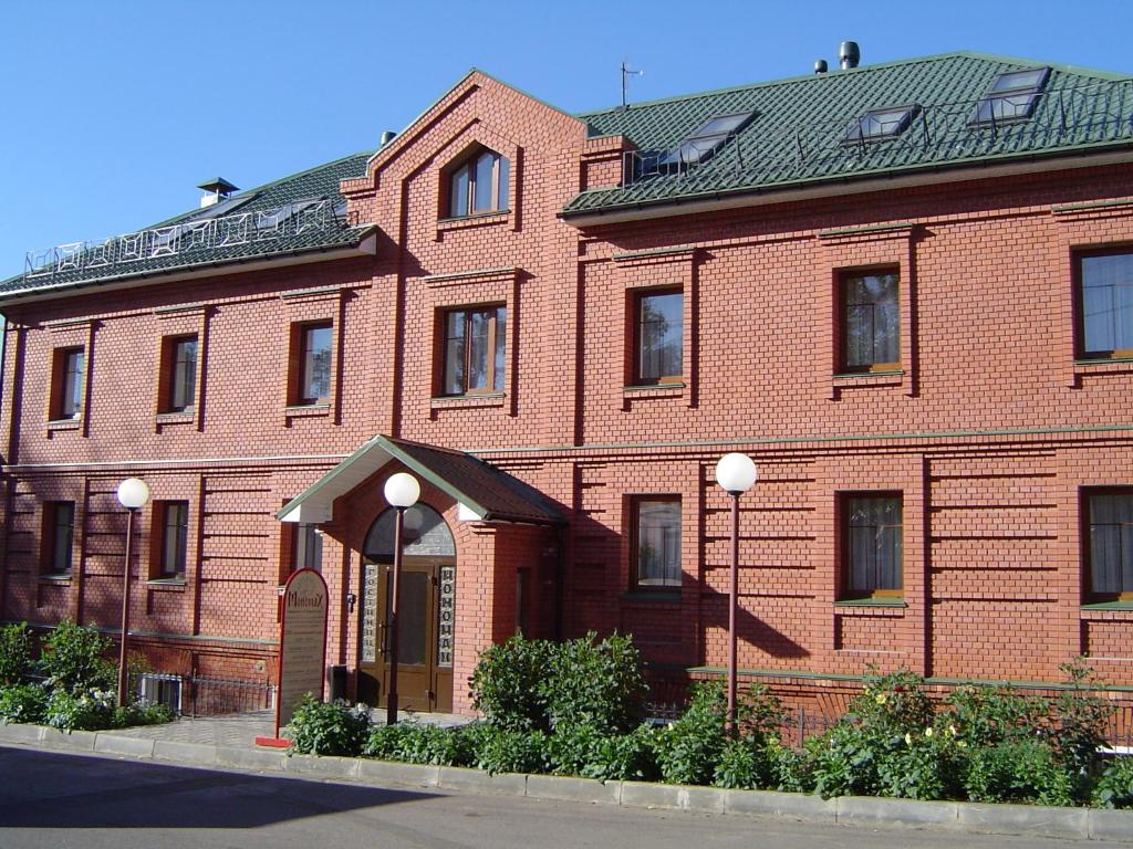 un gran edificio de ladrillo rojo con una puerta arqueada en Monomakh Hotel en Vladimir