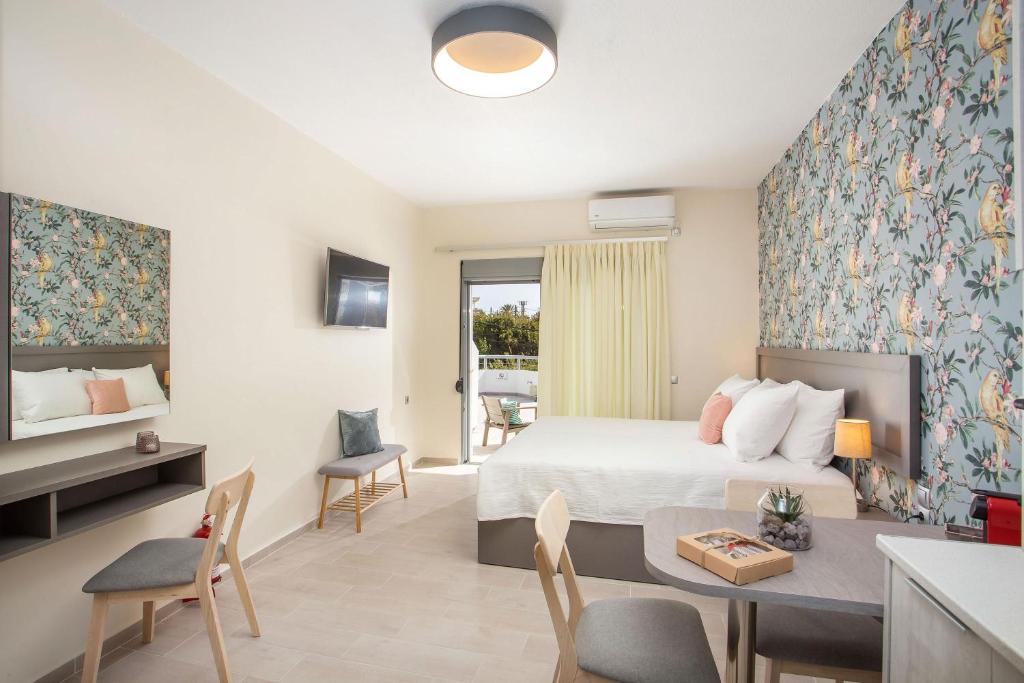 een slaapkamer met een bed, een tafel en stoelen bij Oleana City Center in Rhodos-stad