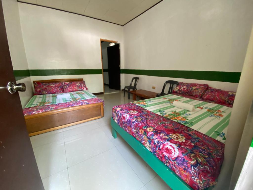 a bedroom with two beds and a door open at RedDoorz @ Classique Pan Oriental Hotel and Resort Batangas in Batangas City