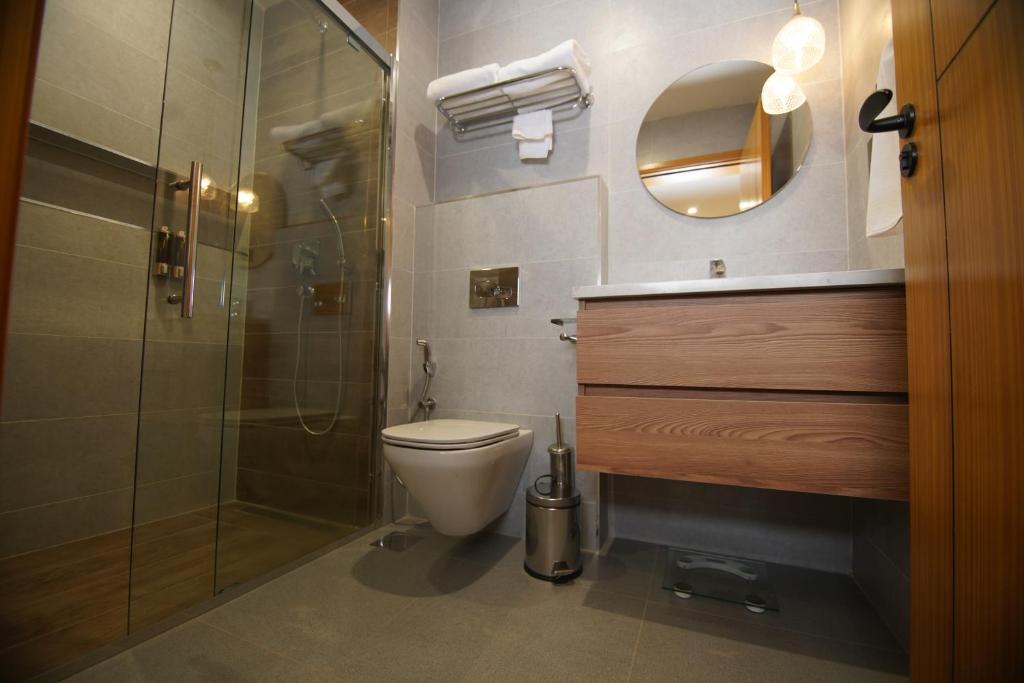 a bathroom with a toilet and a glass shower at Loft Hotel Apartment in Addis Ababa