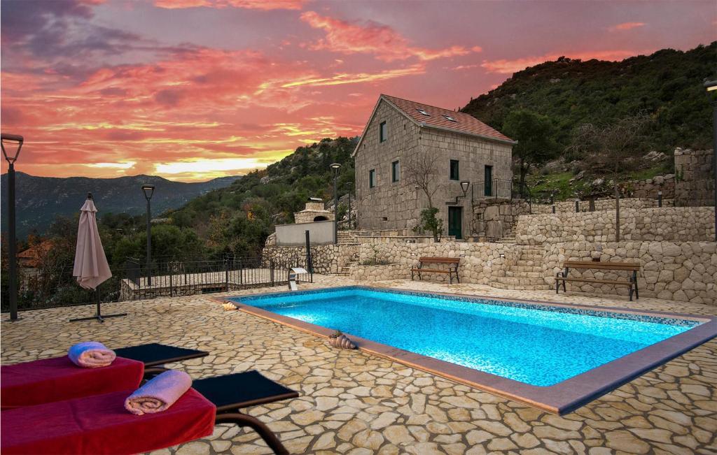 - une piscine en face d'un bâtiment en pierre dans l'établissement Beautiful Home In Vrgorac With Wifi, à Vrgorac