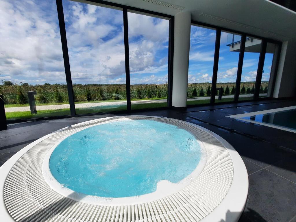 ein großer Swimmingpool in einem Haus mit Fenstern in der Unterkunft 365PAM - Resort Westin House - BASEN, JACUZZI, SAUNA, SIŁOWNIA, PLAC ZABAW W CENIE in Kołobrzeg