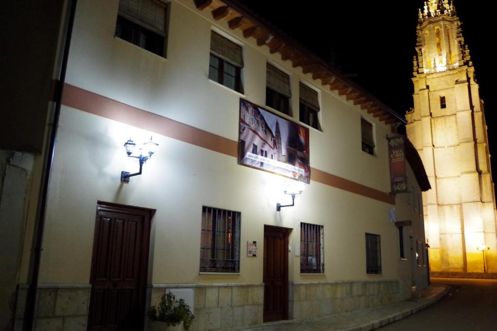 un edificio con una torre de reloj en el fondo en Hotel Rural Villa y Corte, Alojamientos Turísticos, en Ampudia