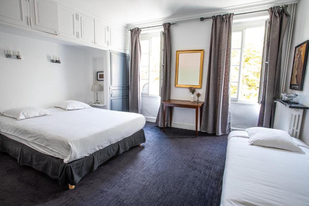 a hotel room with two beds and a window at Hôtel Brasserie du Parc in Albi