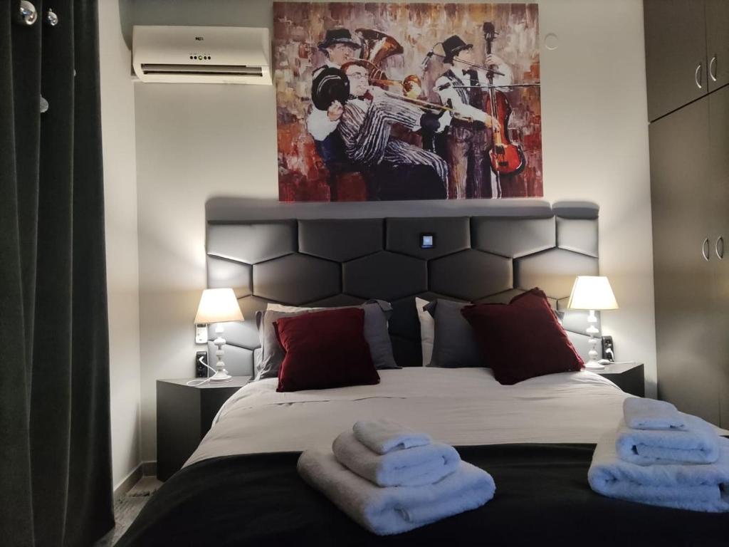 1 dormitorio con 1 cama con 2 toallas en Music Reflections Apartment near Nafplio, en Nea Kios
