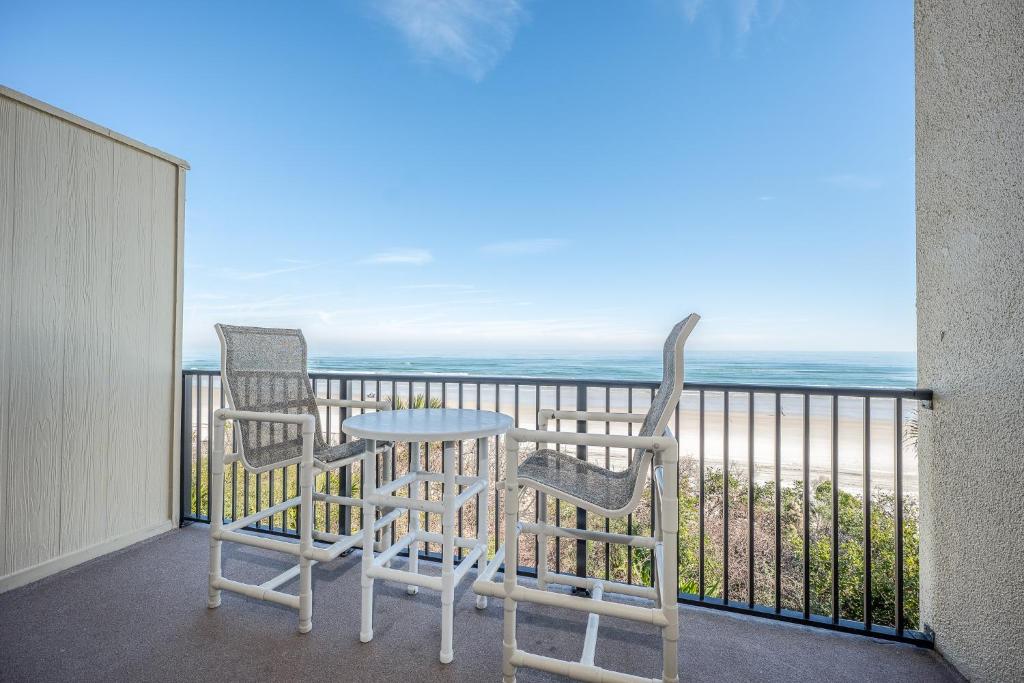 duas cadeiras e uma mesa numa varanda com o oceano em Summerhouse 263, 2 Bedrooms, Sleeps 6, Ocean Front, 4 Heated Pools, WiFi em Saint Augustine