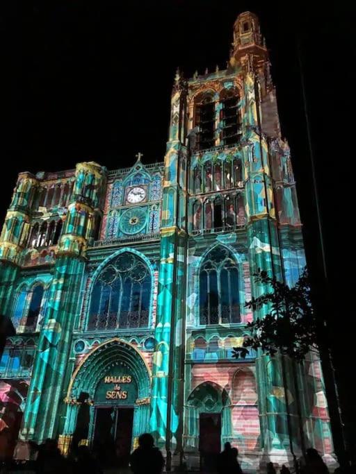 a large building with a clock tower at night at La marbrière, Parking gratuit, proche centre ville in Sens