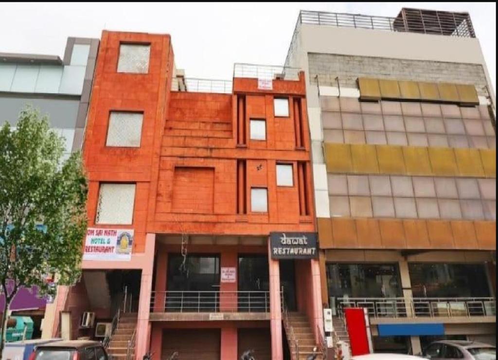 un edificio rojo con un cartel delante en Om Sai Nath Hotel & Restaurant By WB Inn, en Agra