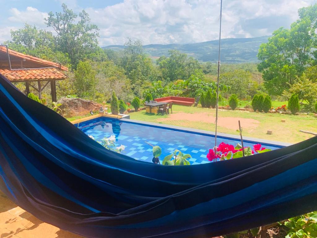 a blue hammock in front of a swimming pool at Casa Upa ,casa con piscina espectacular, Barichara in Barichara