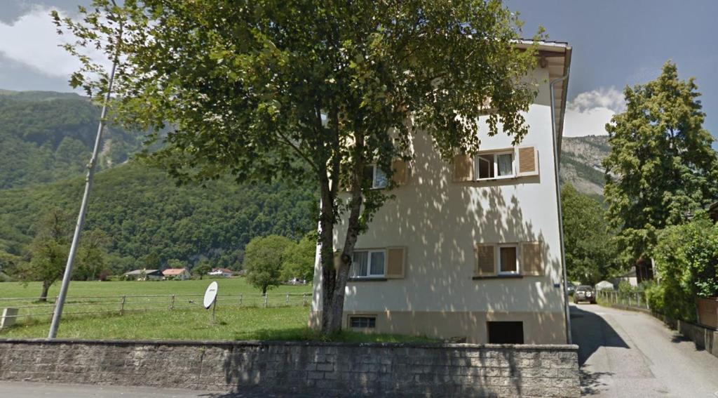 un edificio con un albero accanto a una strada di 24-7 Rooms a Sennwald