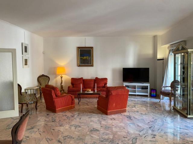 a living room with red chairs and a flat screen tv at VHOMETREVI in Rome