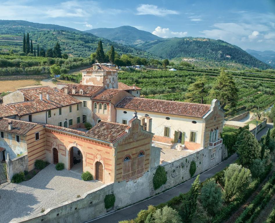 an aerial view of a villa with mountains in the background at Palazzo Montanari Art & Wine Luxury Apartments in Fumane