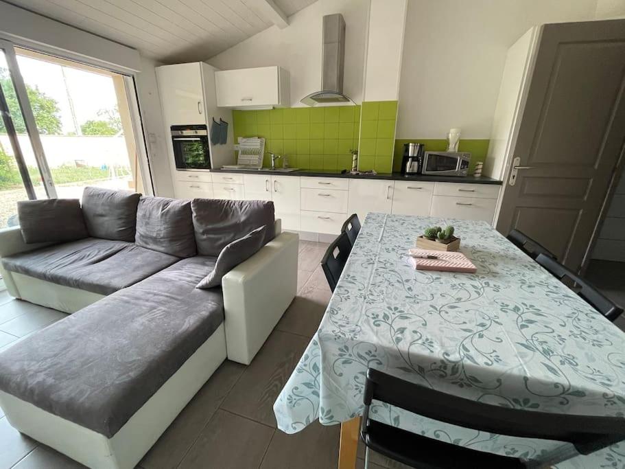 a living room with a couch and a table at Les Lys de Rosie - Maison familiale de plain pied campagne in Boisset-lès-Montrond