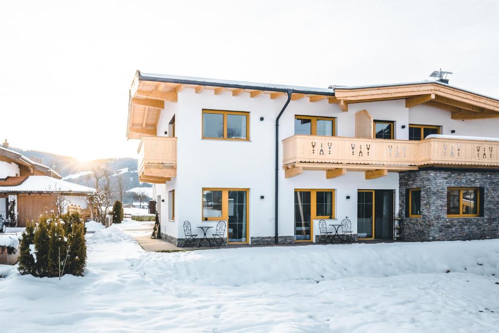 a house with a balcony in the snow at Tiroli in Westendorf