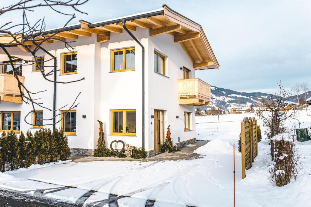 Casa blanca con balcón en la nieve en Tiroli en Westendorf