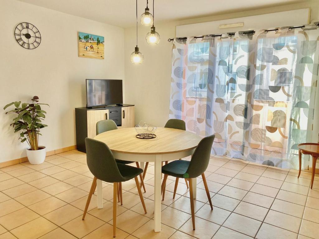 ein Esszimmer mit einem Tisch und Stühlen in der Unterkunft Beaux Arts T3 Duplex, Rénové Lumineux + Garage in Montpellier