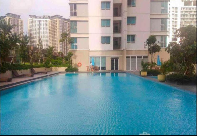 einem großen blauen Pool vor einem Gebäude in der Unterkunft 2BR Apt Springhill Terrace, Golf View in Jakarta