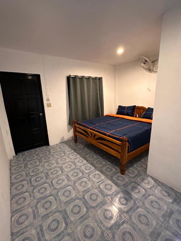 a bedroom with a bed with a blue comforter at Divers House in Ko Tao