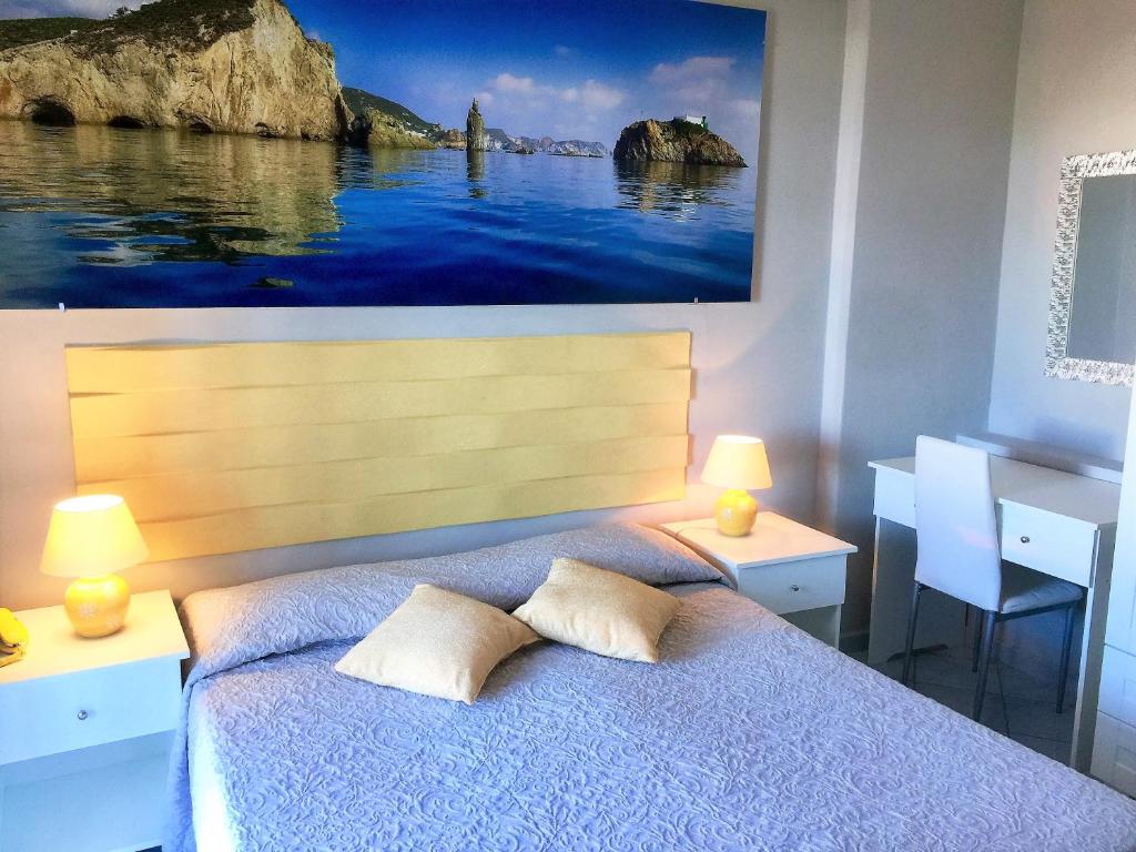 een slaapkamer met een bed met een schilderij aan de muur bij Hotel Ortensia in Ponza
