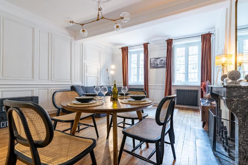 a dining room with a table and chairs and a fireplace at L' ALCOVE- Confort Charme Downtown in Dijon