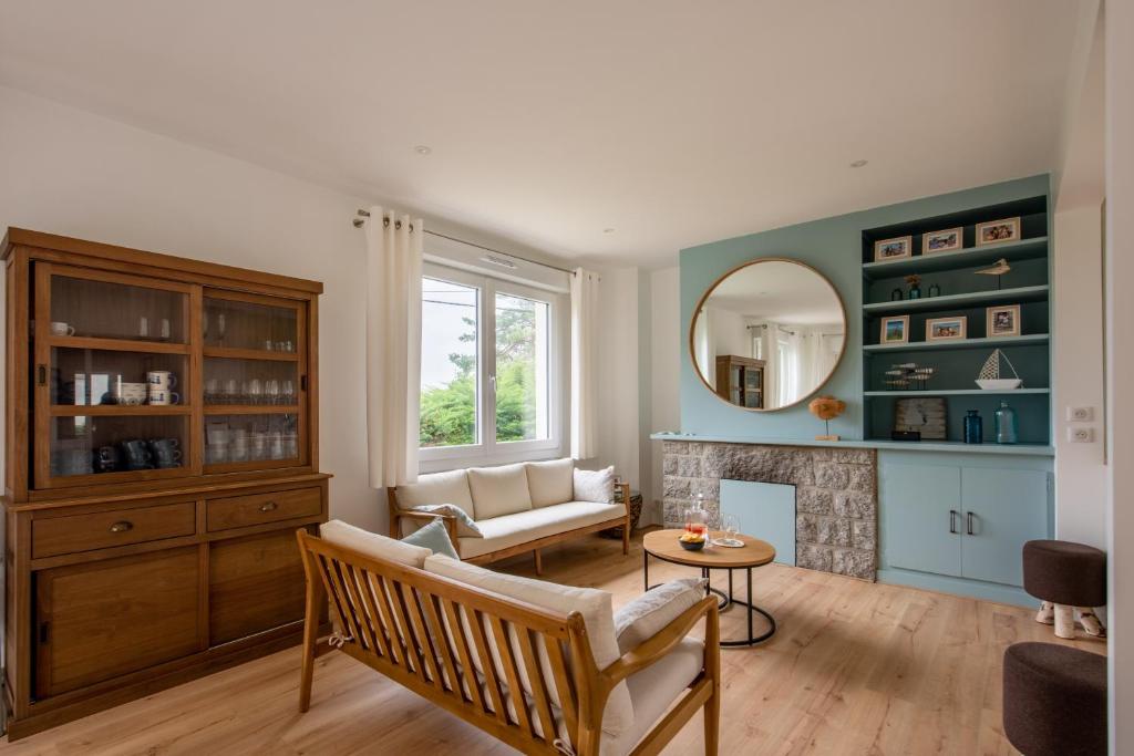 un salon avec une cheminée et un miroir dans l'établissement Les Roches Plates, à Fréhel