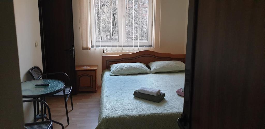 a bedroom with a bed and a table and a window at Casa Rosa in Băile Olăneşti