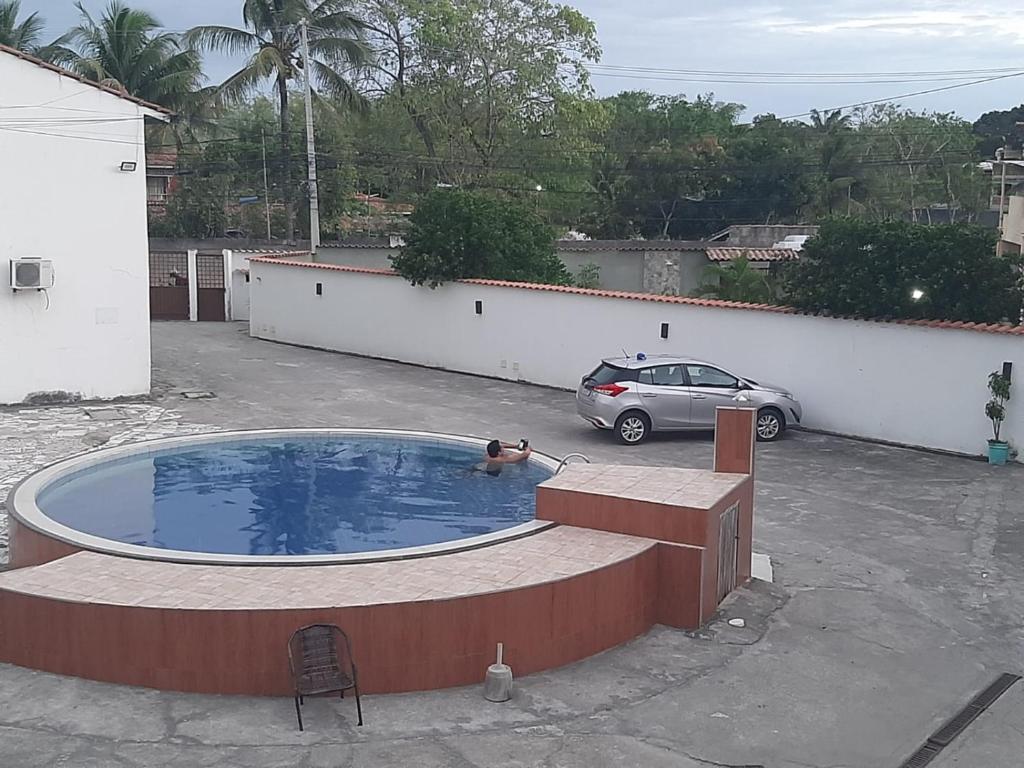 una piscina en un aparcamiento con coche en Apartamento.mutchisma5, en Porto Seguro