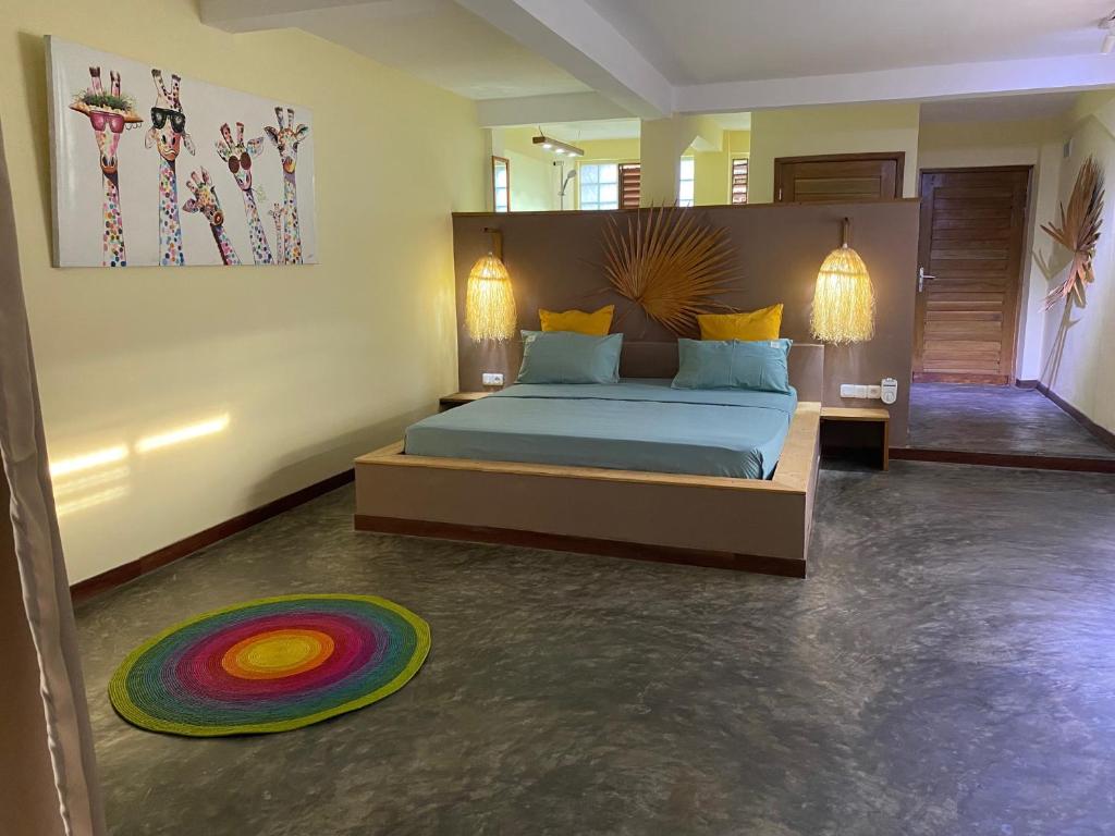 um quarto com uma cama grande e um tapete colorido em La perle rare de Nosy be em Ambatoloaka