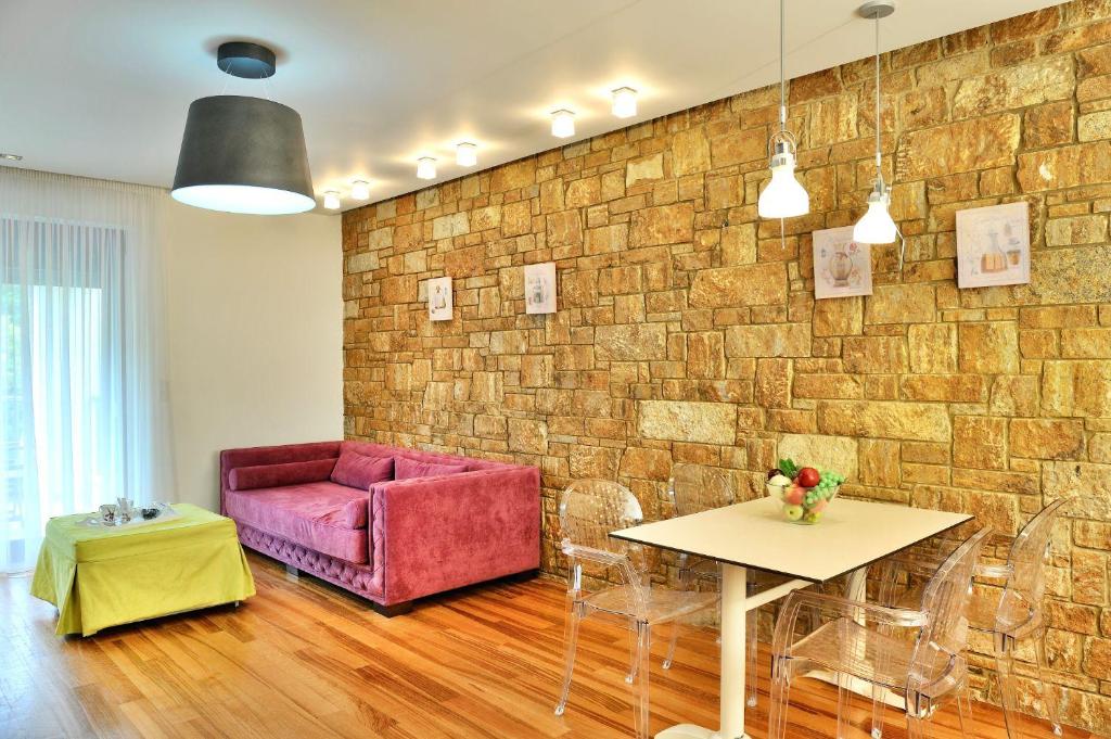 a living room with a pink couch and a table at Sani Polyastron Hotel & Spa in Sani Beach