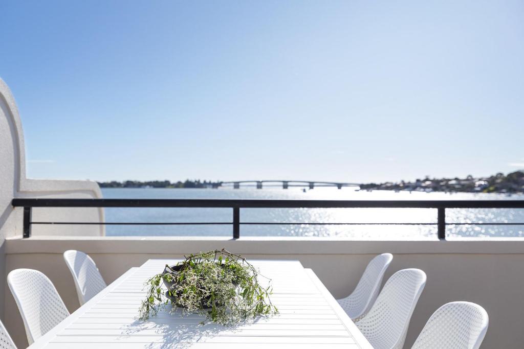 d'une table et de chaises sur un balcon donnant sur l'océan. dans l'établissement Panoramic Water View Apartment, à Sylvania
