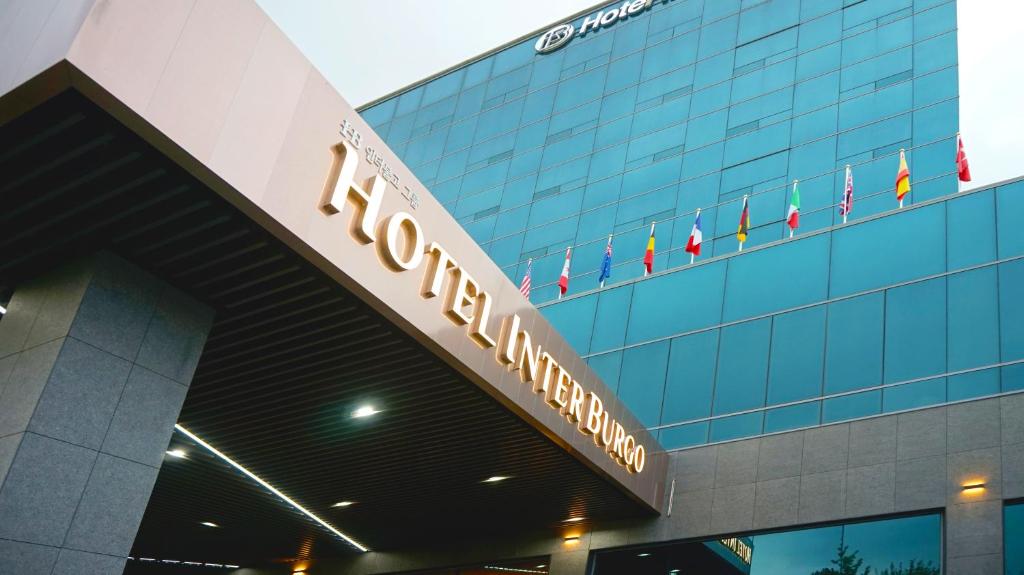 a sign on the front of a building with flags at Interburgo Hotel Wonju in Wonju