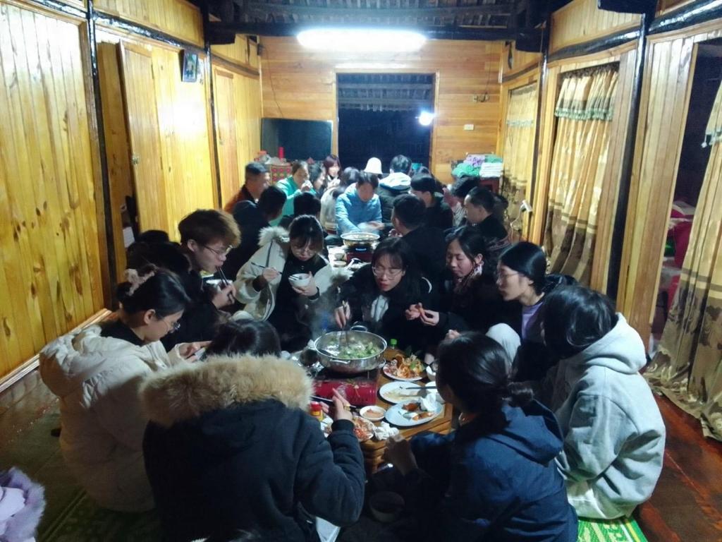 um grupo de pessoas sentadas à volta de uma mesa a comer em Trường Giang Homestay em Cao Bang