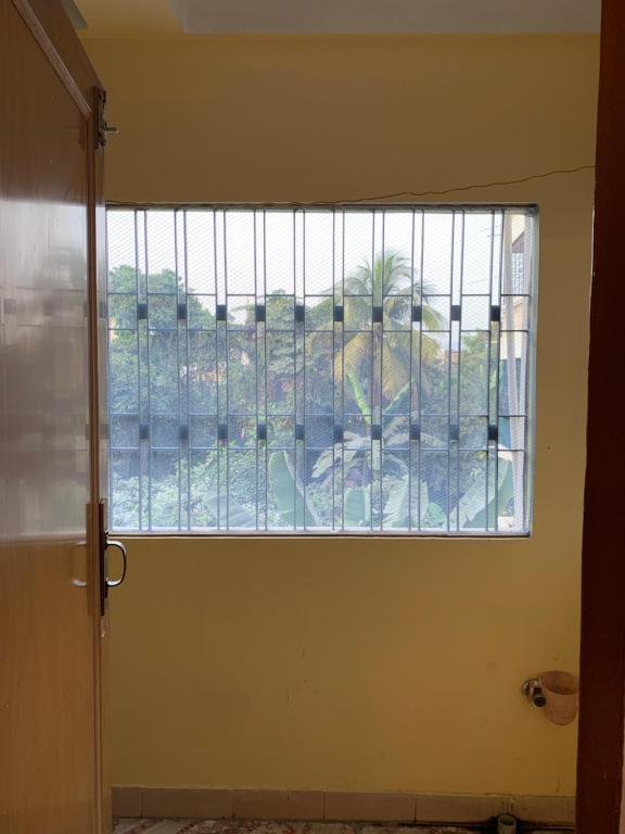 une porte ouverte avec une fenêtre dans une pièce dans l'établissement Raga Homestay 2BHK- A homely guesthouse experience, à Guwahati