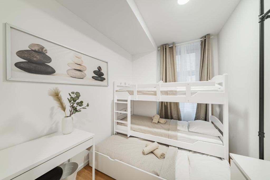 a bedroom with two bunk beds and a desk at Central City Rooms by HOME2 in Vienna